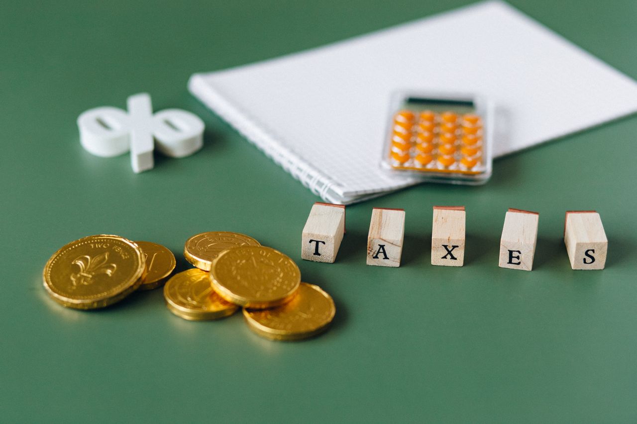 Configuración con monedas, calculadora y letrero de impuestos para el IVA